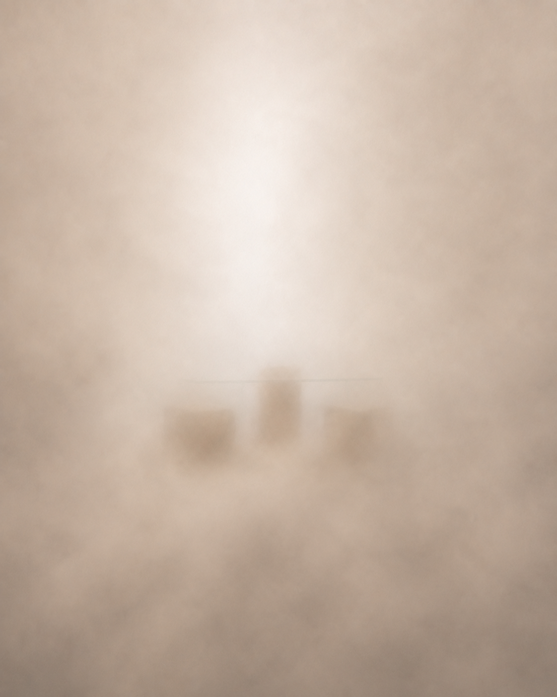 A softly veiled sculptural furniture silhouette in warm, neutral light